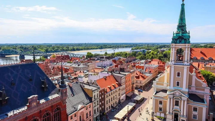 Obrazek przedstawia grafikę promocyjną wydarzenia Jednodniowa wycieczka do Torunia z Warszawy